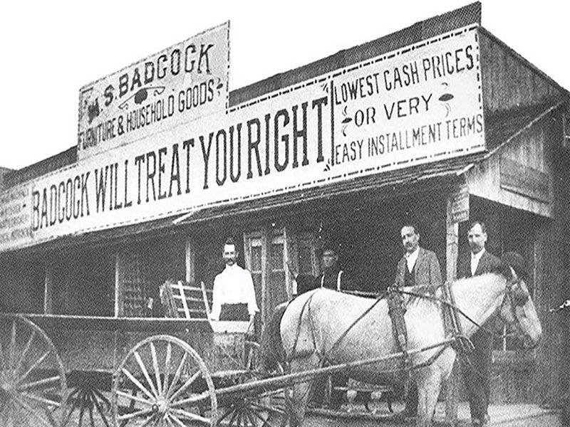 Image of four men with horse and buggy outside of the original Badcock store